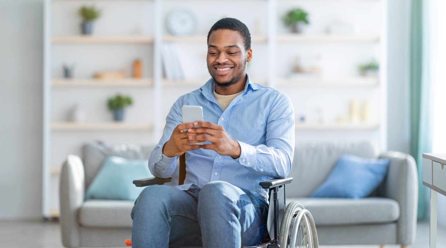 man in wheelchair using smartphone